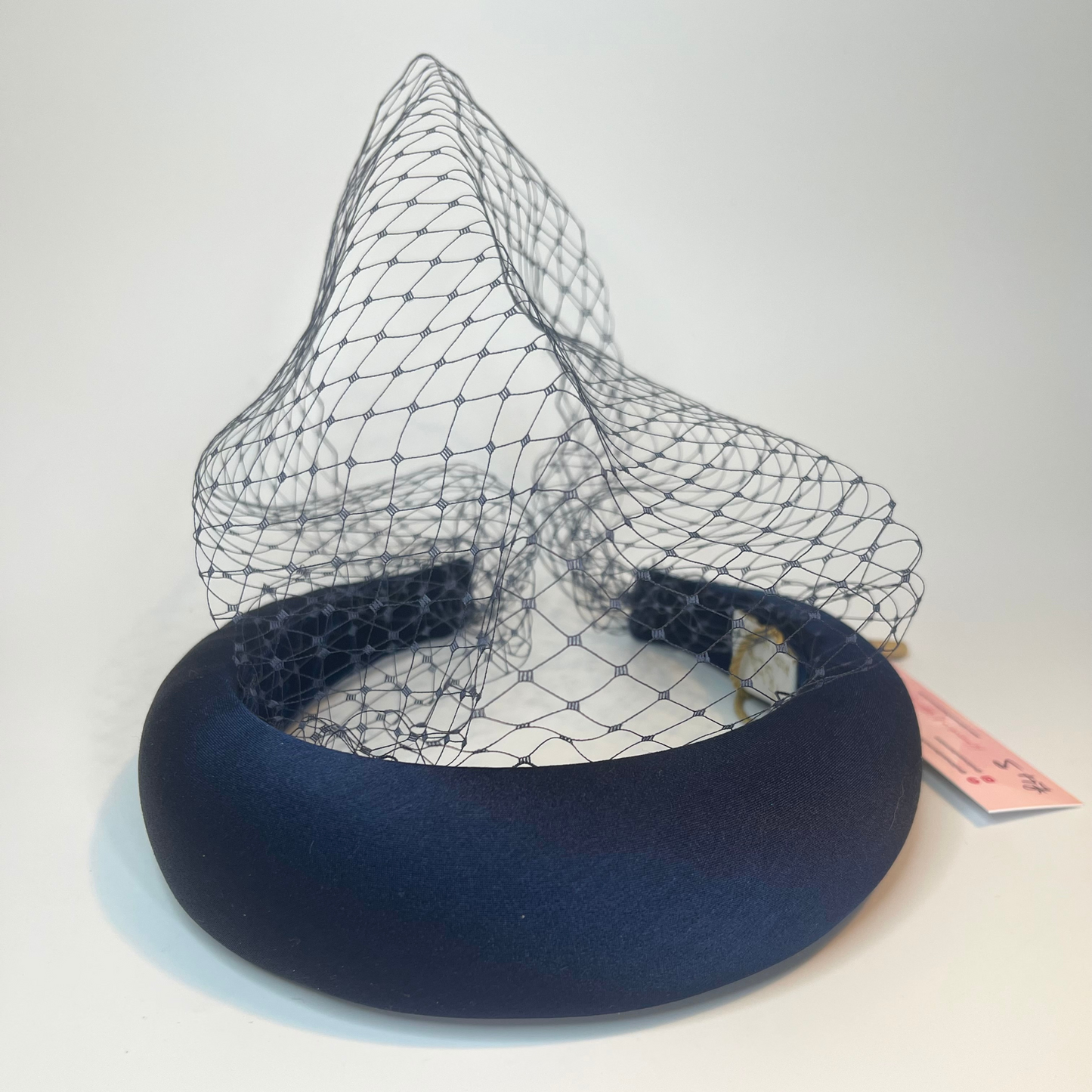 Navy padded headband with an attached navy, net veil