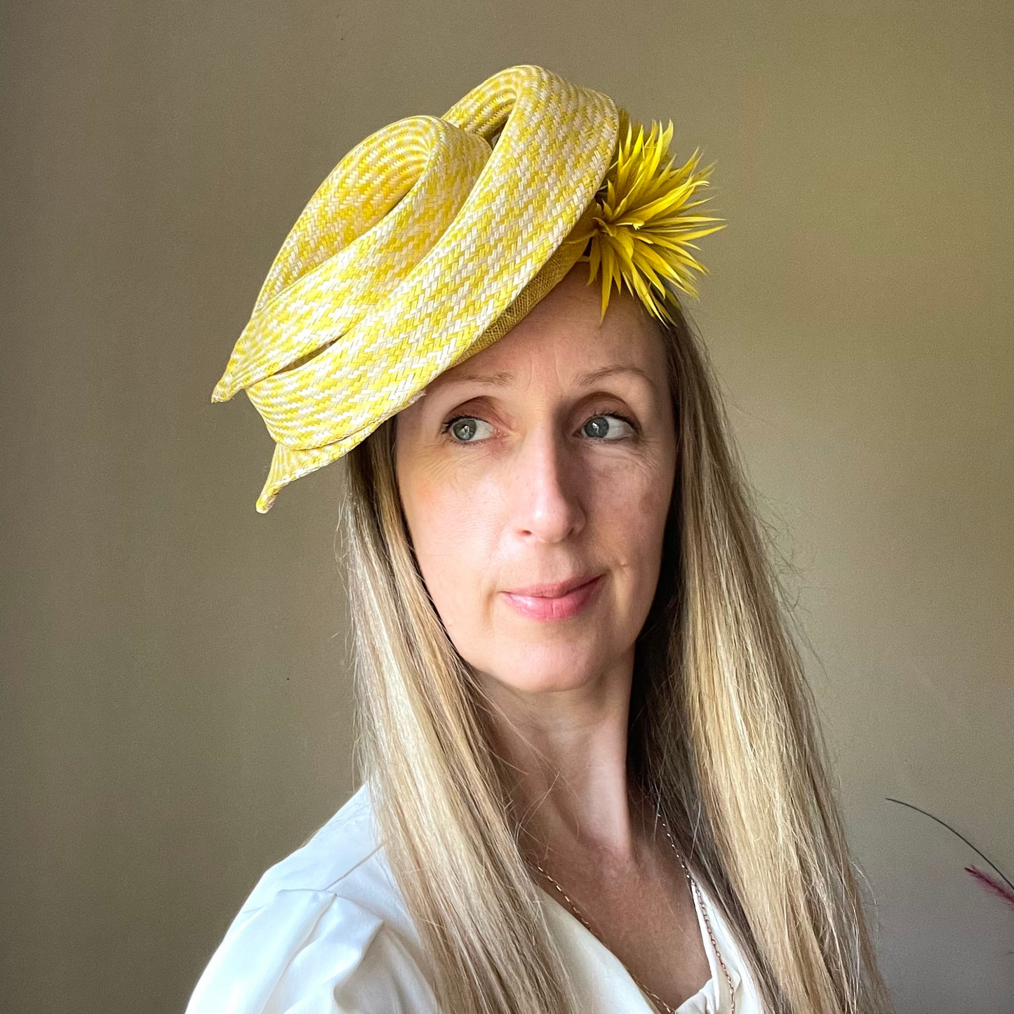 yellow and white spiral headpiece made from buntal straw