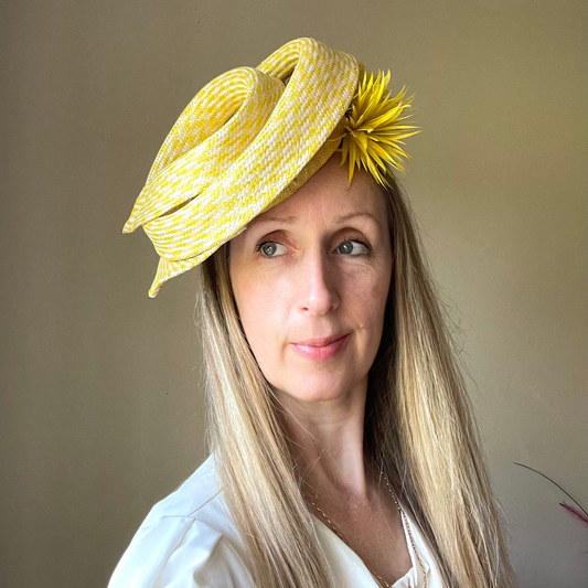 yellow and white spiral headpiece made from buntal straw  