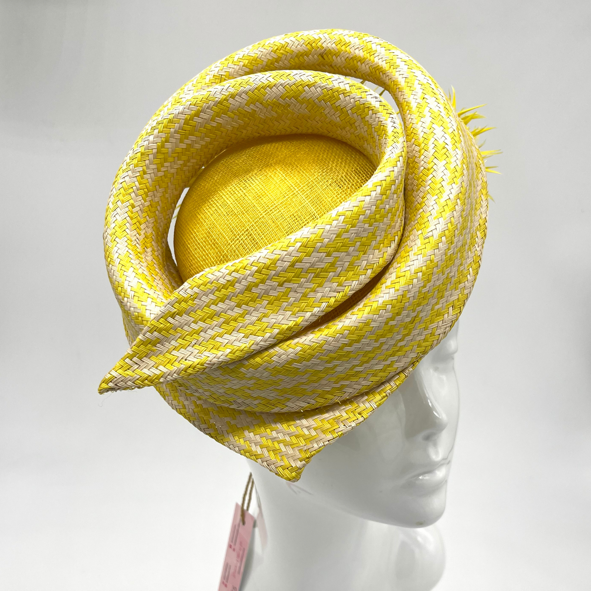 yellow and white spiral hat with goose biot pom poms